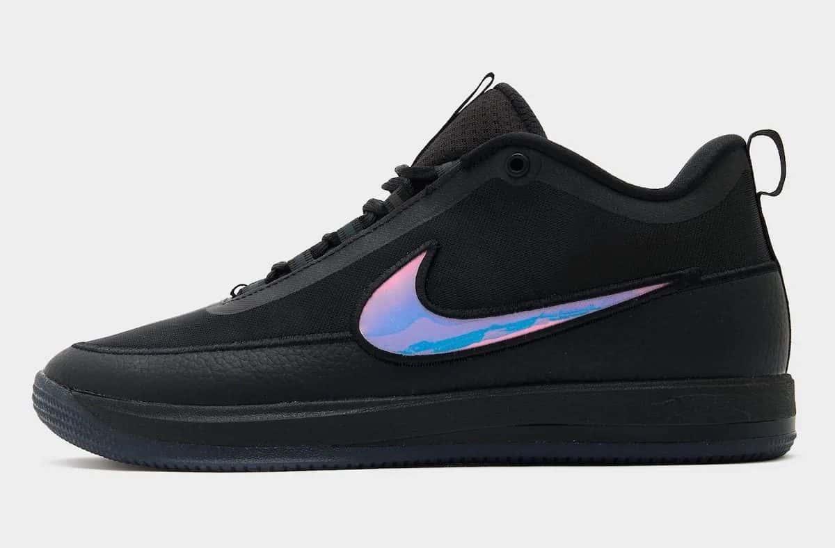 Nike Book 2 Desert Night de perfil, todo en negro, con un Swoosh iridiscente en tonos rosa, azul y dorado y suela translúcida oscura