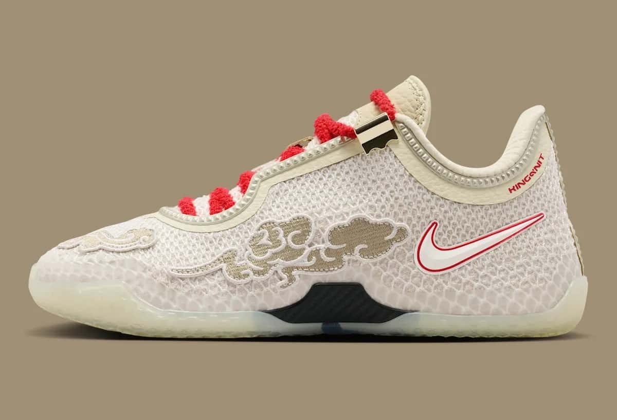 Nike LeBron 24 Greater China de perfil sobre fondo caqui, con upper de KingKnit beige, nubes bordadas en dorado, Swoosh blanco con borde rojo, cordones rojos afelpados y suela translúcida