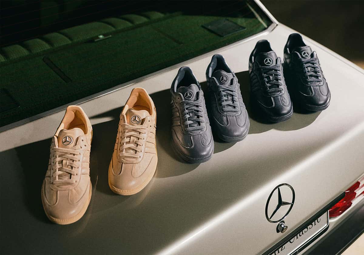 Los tres pares del adidas Samba OG x Mercedes-Benz en beige, gris y negro apoyados sobre el baúl de un Mercedes clásico