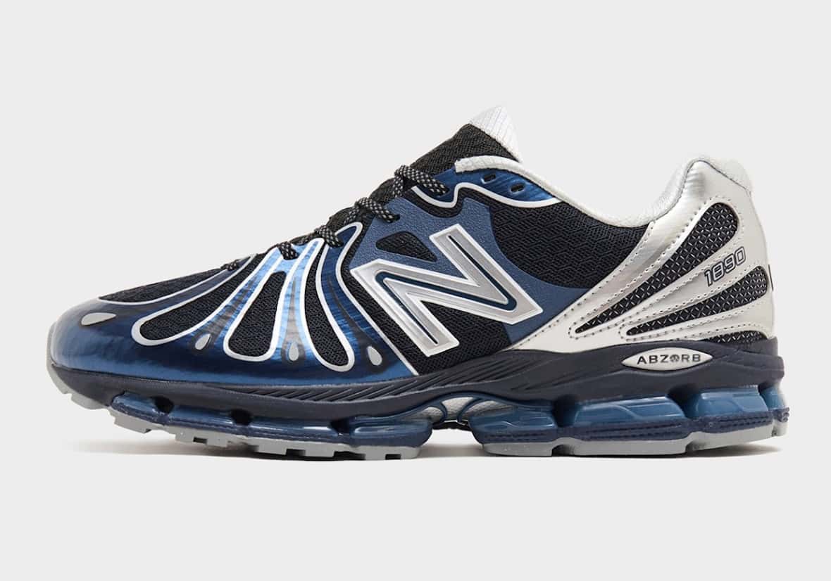 New Balance 1890 Metallic Blue de perfil lateral sobre fondo gris claro, con overlays azul metalizado en la puntera, mesh negro, N plateada, talón plateado con el número 1890, mediasuela azul marino y cápsulas ABZORB azules translúcidas